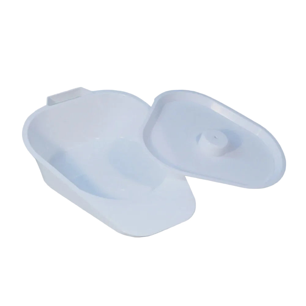 A plastic slipper bedpan with lid, in a light color, typically used for bedridden individuals.