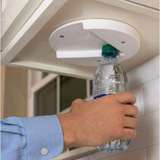 A person's hands using an under bench jar opener on a water bottle, mounted on a white flat surface.